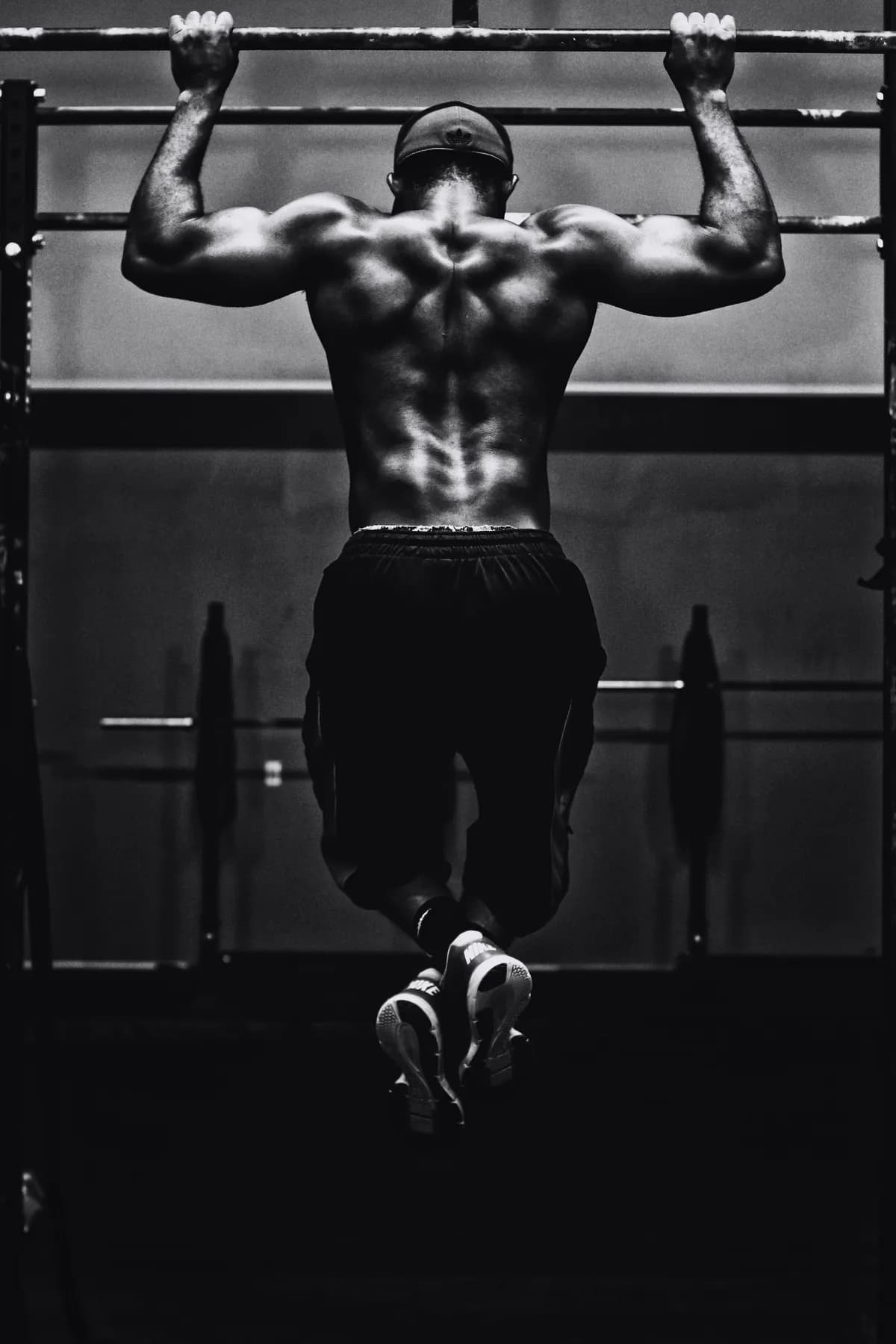An athlete at the top of a pull-up, shot from behind.